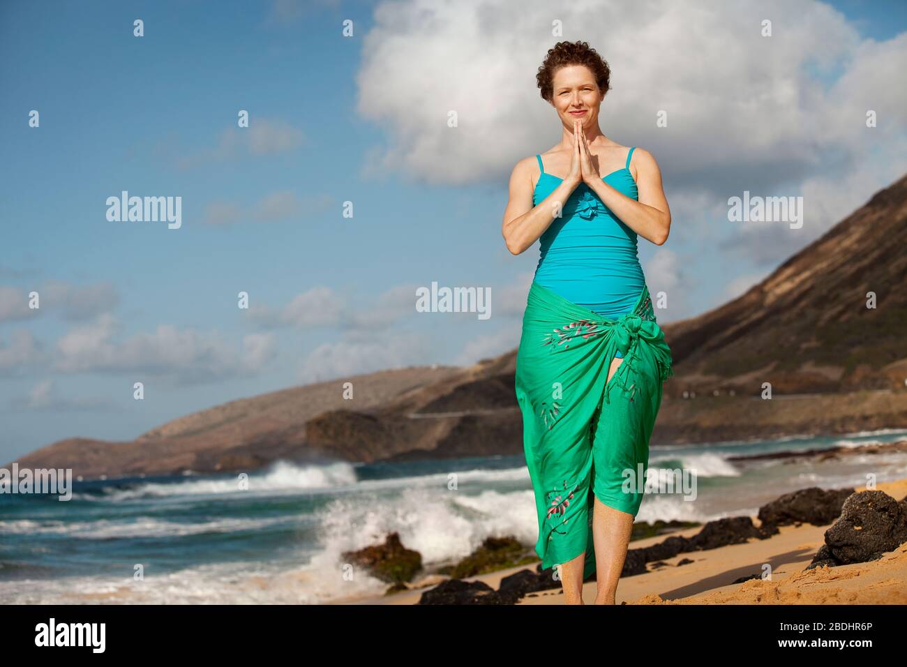 Mitte der erwachsenen Frau im Gebet Lage am Strand. Stockfoto