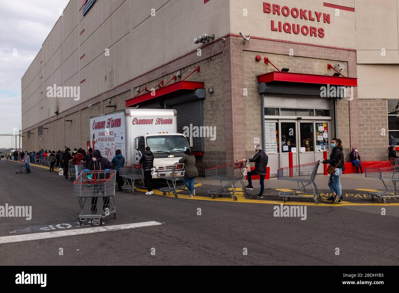 Brooklyn, New York - 7. April 2020. Bis 9:30 UHR erstreckt sich die Linie, um das Lebensmittel- und Lagerhaus Costco an der 3rd Avenue zu betreten, bereits über die Vorderseite des Gebäudes und West auf der Länge der Südseite zurück zur 2d Avenue, nördlich über die Rückseite des Ladens. Nach Osten über die Nordseite des Ladens und wickelt sich weiter um die Vorderseite zum Eingang. Dieser Teil der Linie befindet sich auf der Südseite des Ladens. Das Geschäft öffnet dienstags bis donnerstags von 8 bis 9 UHR für Kunden über 60, aber einige Kunden unter 60 wurden vor 8 erwartet. Stockfoto