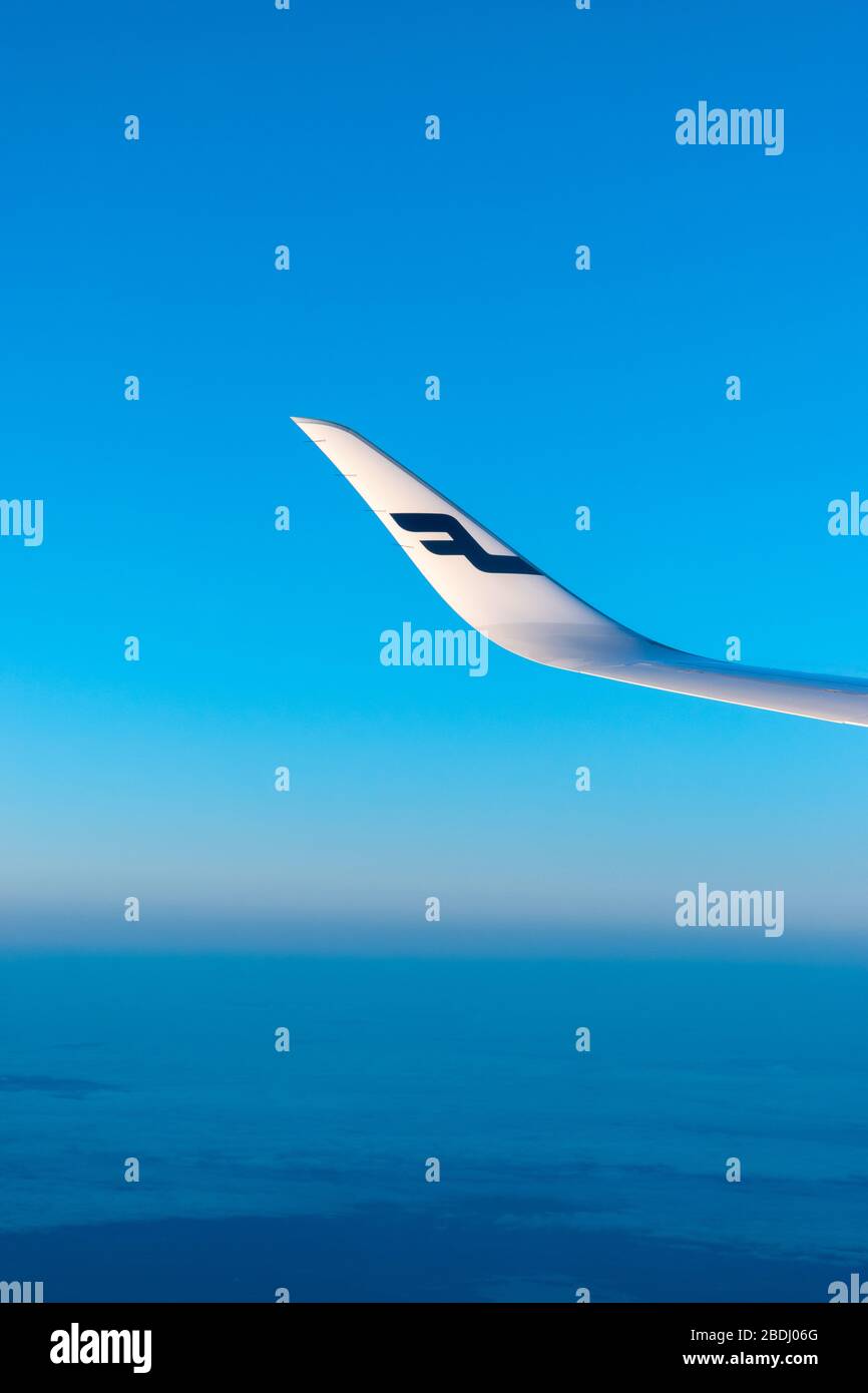 Finnland Helsinki 2 MAR 2020 blaues Finnair-Fluglinien-Logo auf dem Flugzeugflügel vor dem blauen Himmel und dem blauen Erdhorizont während des Sonnenuntergangs Stockfoto