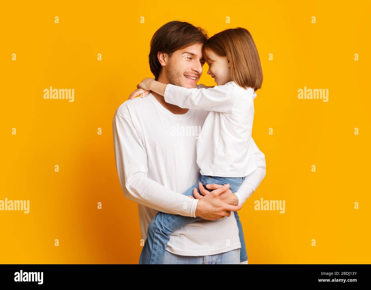 Vater und Tochter kleben über gelben Hintergrund Stockfoto