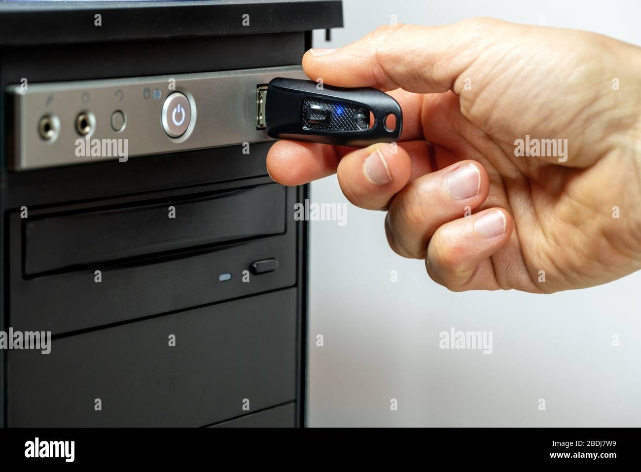 Schließen Sie ein USB-Flash-Laufwerk von Hand an einen Computer an. Stockfoto