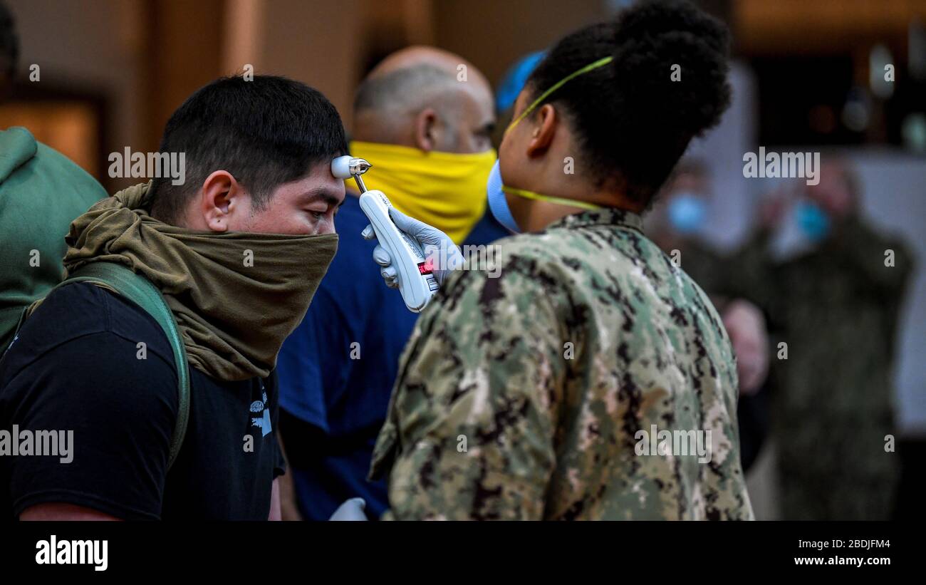 Segler der US-Marine, die dem Flugzeugträger USS Theodore Roosevelt zugeordnet sind, werden vor der Verlegung in lokale Hotels untersucht, um den Ausbruch von COVID-19, Coronavirus 7. April 2020 im APRA Harbour zu verhindern. Stockfoto