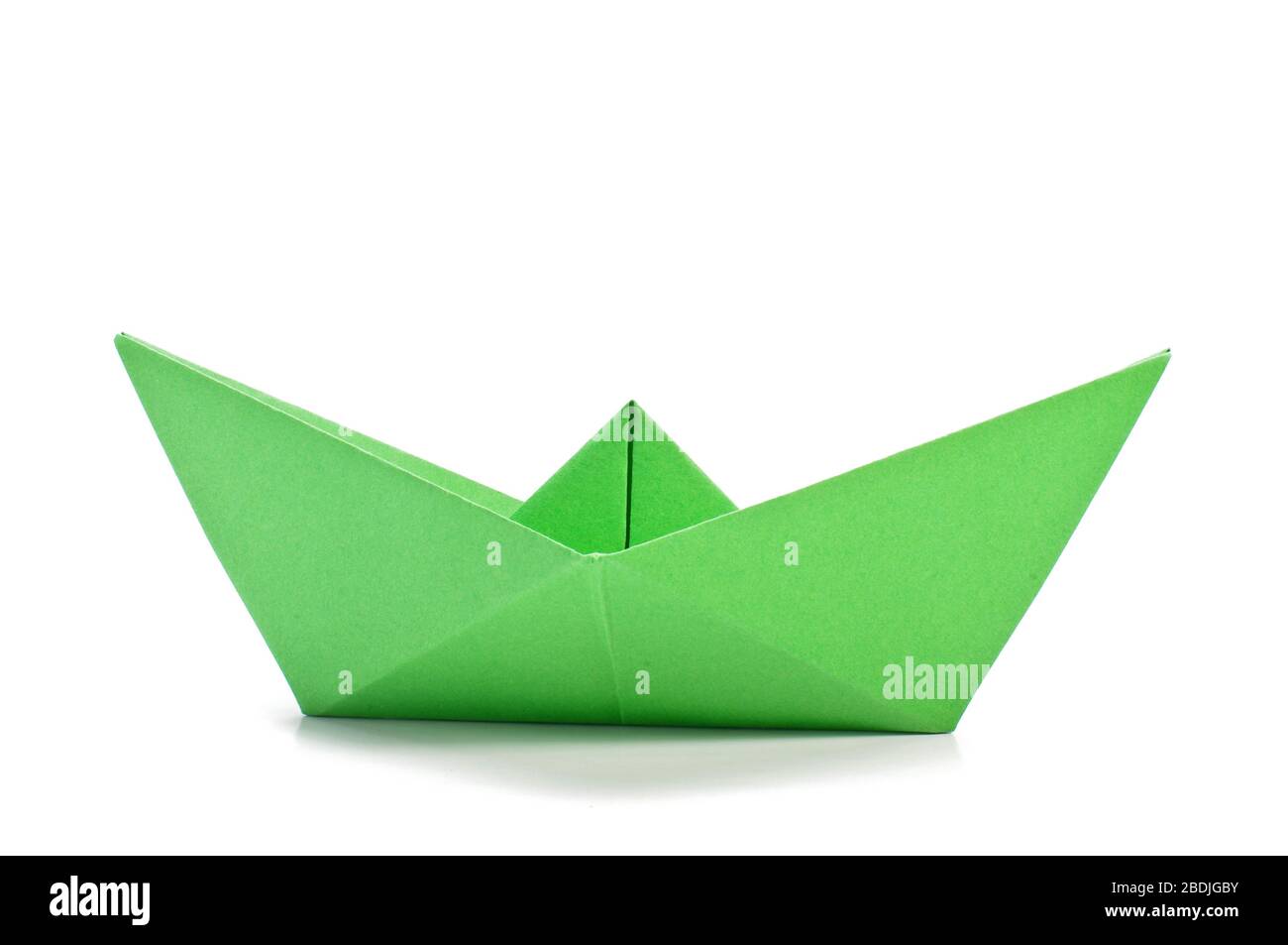 Grüne Origami-Schiffsseite auf dem weißen Hintergrund isoliert Stockfoto