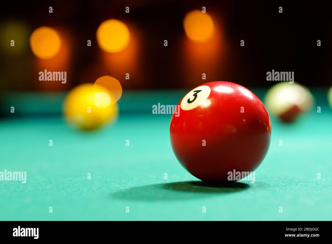 Roter Poolball Nummer 3 auf dem Billardtisch Stockfoto