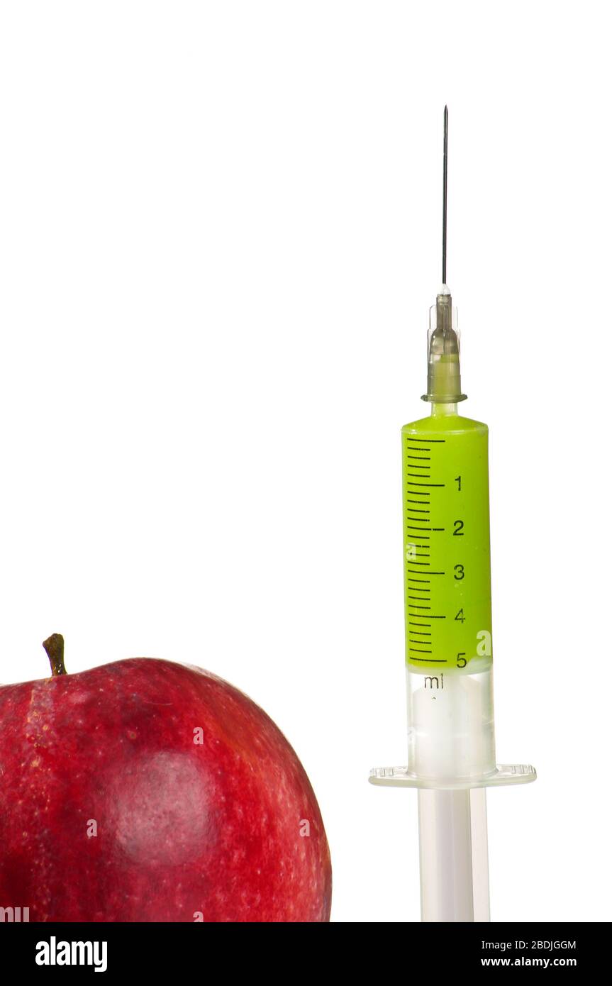 Spritze mit grünem Serum und rotem Apfel Stockfoto