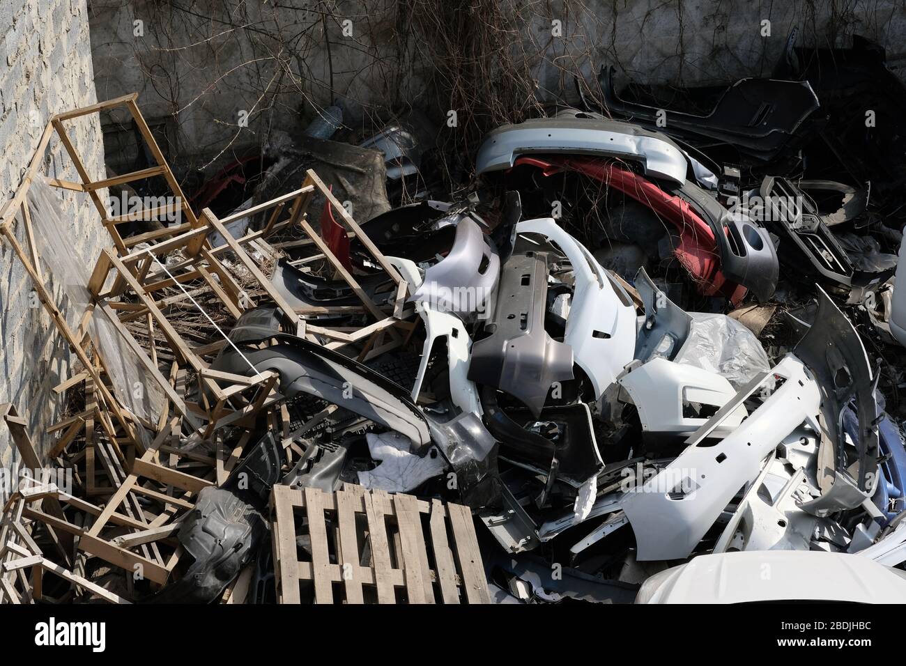 Müllhalde alter Autoteile in der Stadt. Ein Berg von Altmetall aus Autos, Holzpaletten und Bretter. Berg des Mülls. Stockfoto