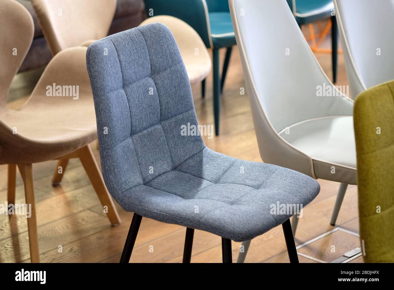 Grauer Stuhl auf Holzbeinen. Stühle im Präsentationsraum. Textilmöbel,  ergonomische, militante Sessel Stockfotografie - Alamy