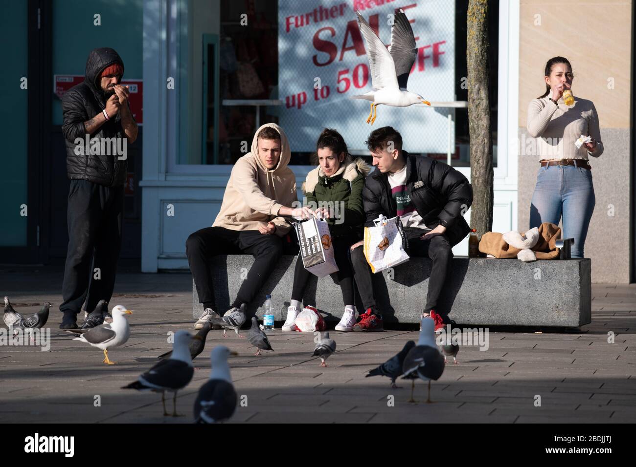 Die Menschen entmutigen die Regeln der sozialen Distanzierung in einem ruhigen Stadtzentrum von Cardiff während der Sperrung des Coronavirus (COVID-19). Stockfoto