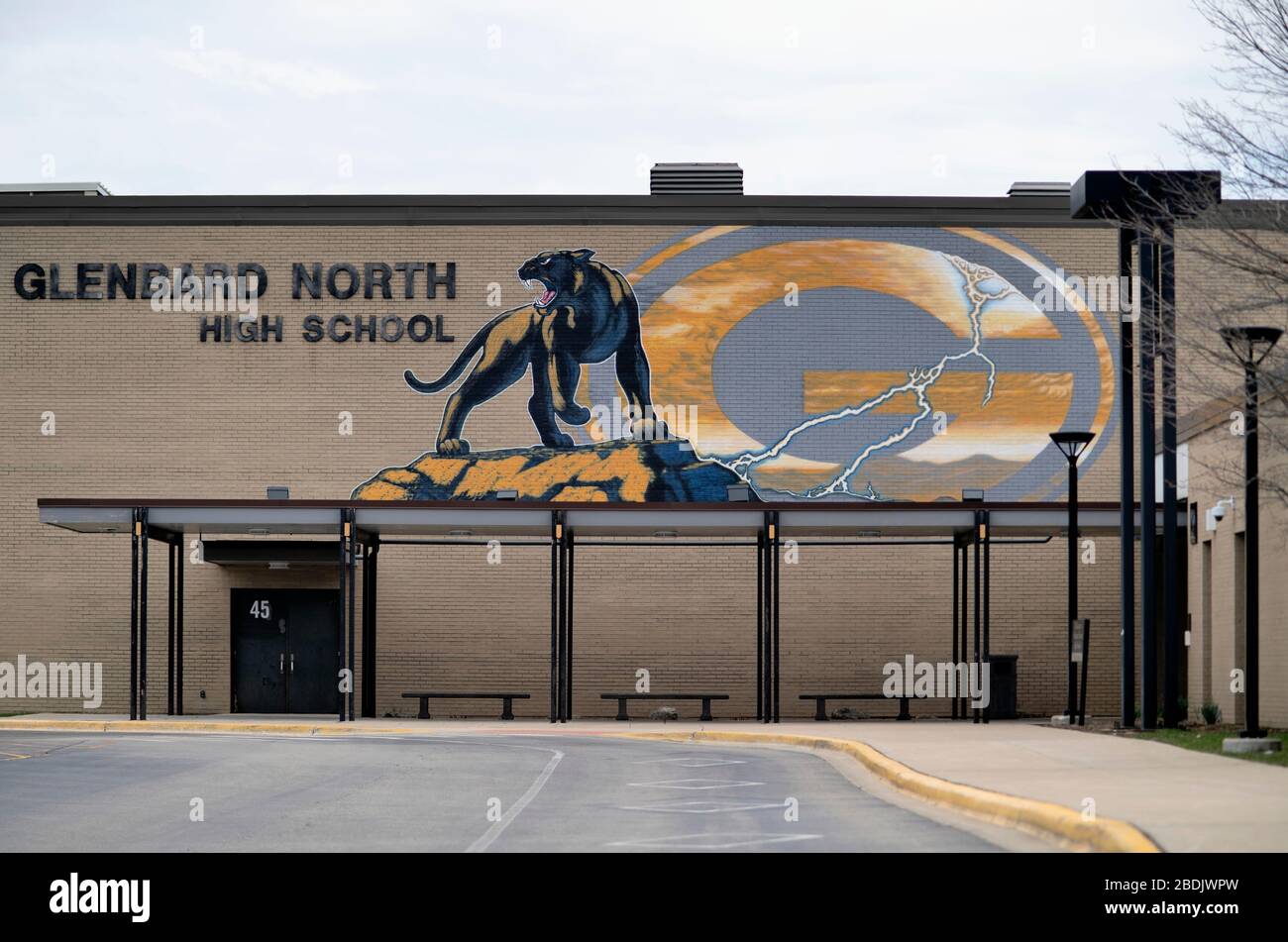 Carol Stream, Illinois, USA. Ein verlasser Parkplatz und ein Eingangsbereich einer Highschool unterstreichen die Reaktion auf die Coronavirus-Pandemie in den USA. Stockfoto