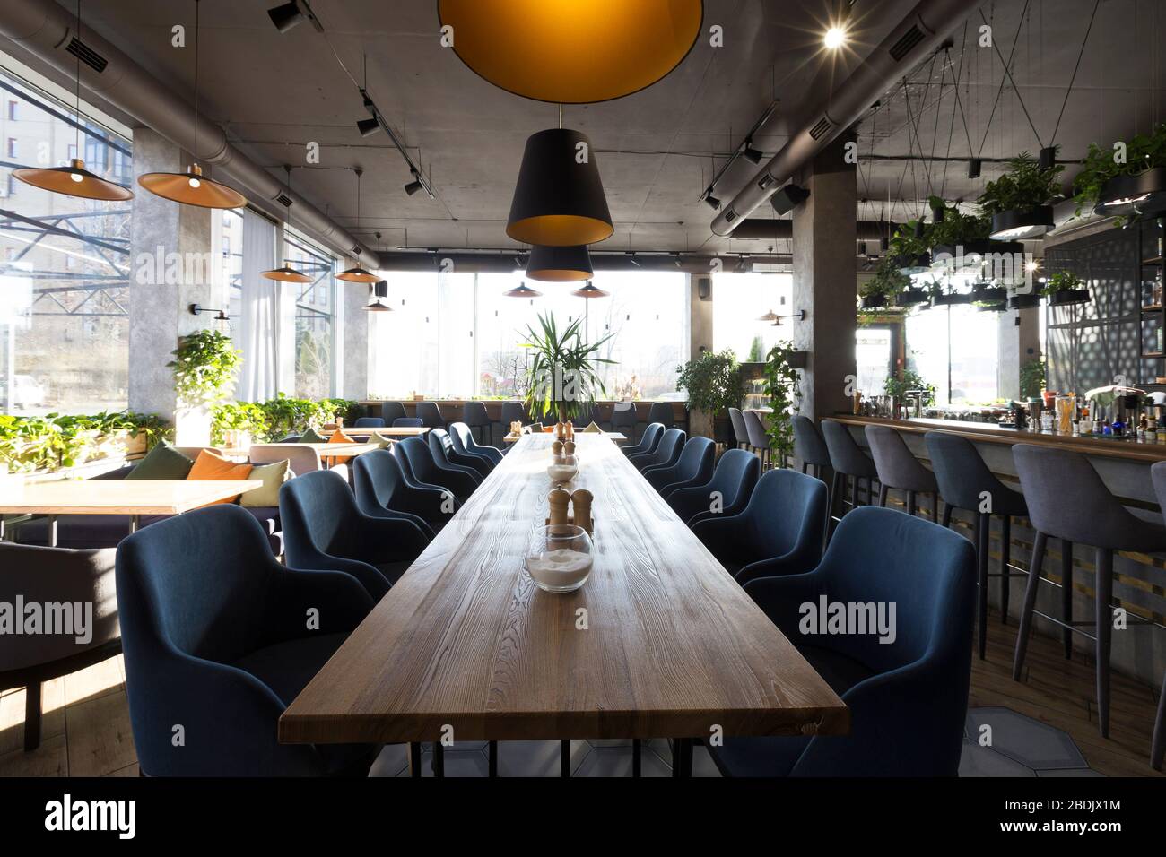 Langer Tisch für große Unternehmen im gemütlichen Café-Interieur, niemand im Haus Stockfoto