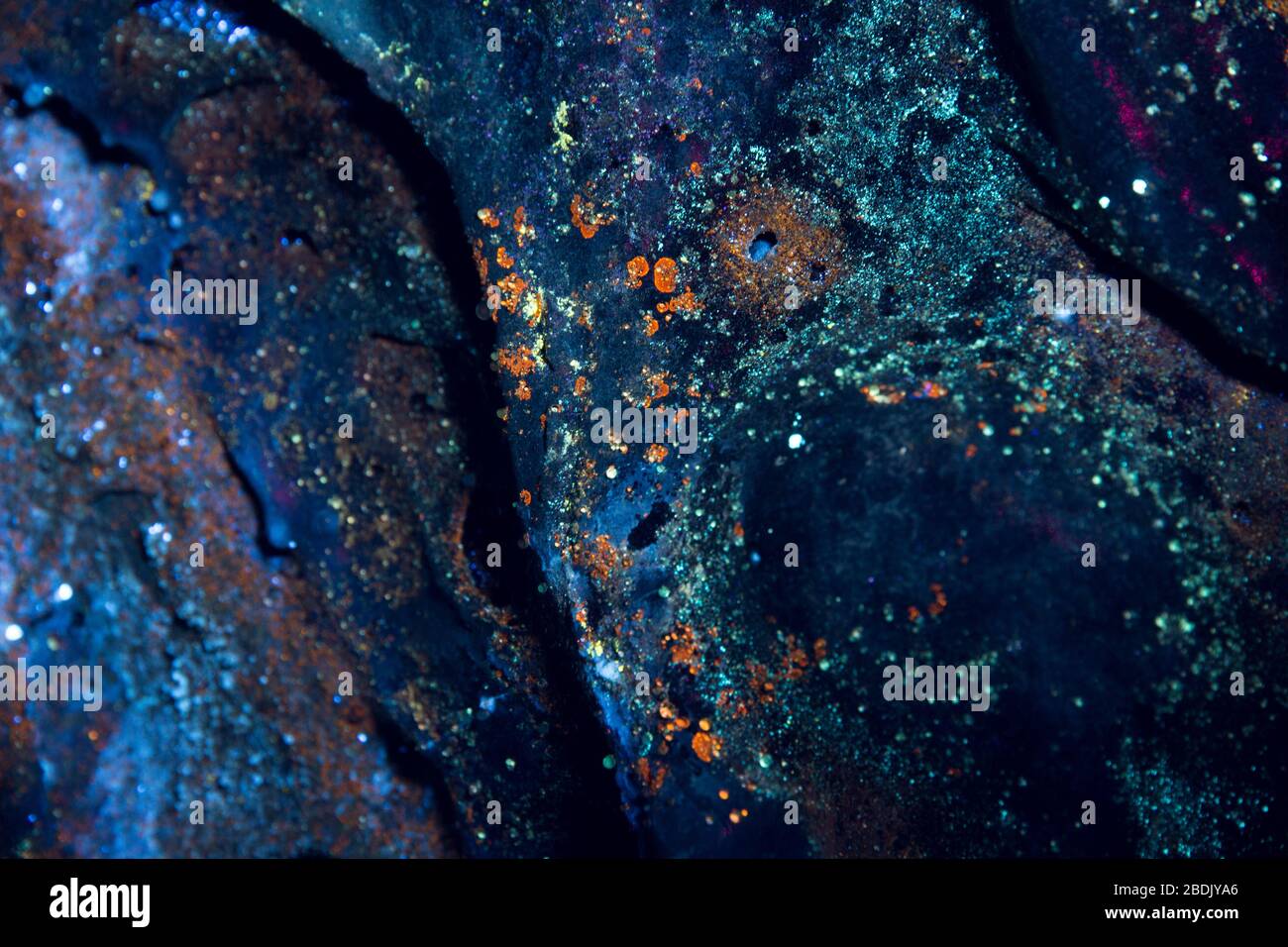 Mikrobielle Organismen unter ultraviolettem Licht in einer Lavaröhrenhöhle Stockfoto