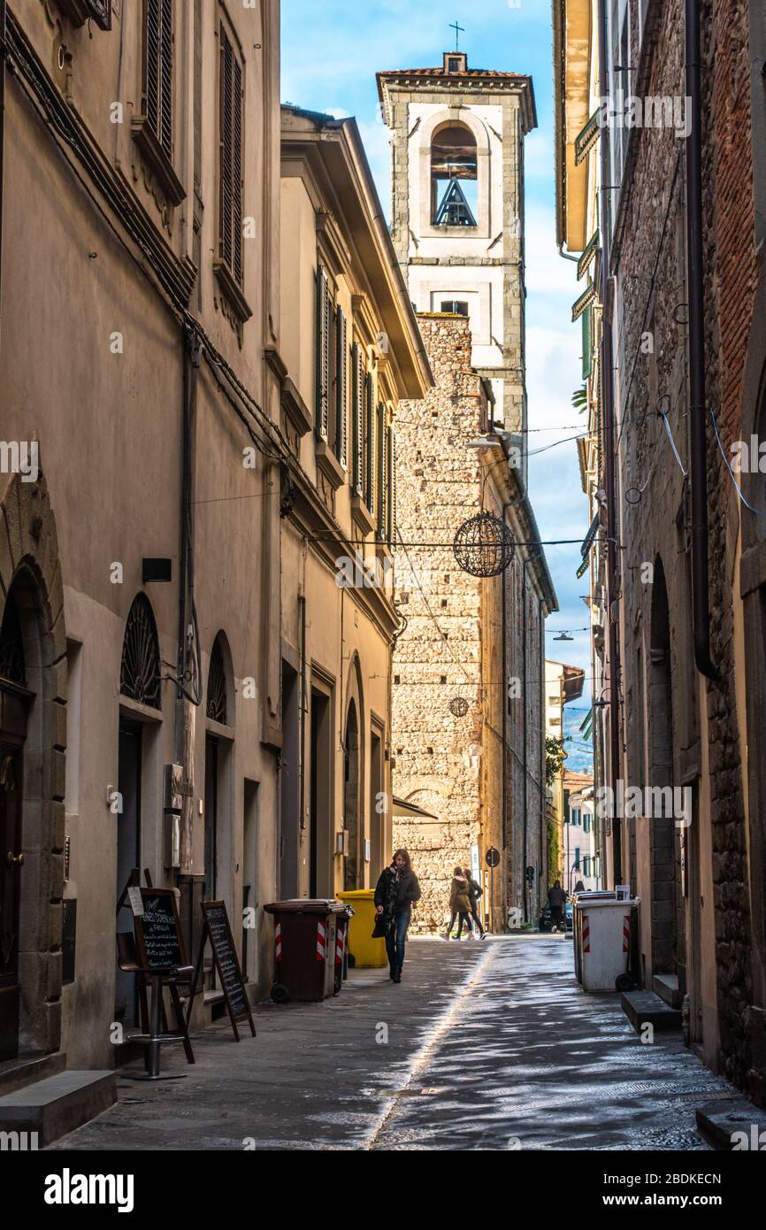 Eine typische Straße der Altstadt von Pistoia mit der Turmglocke der Kirche von Santo Spirito. Pistoia, Toskana, Italien, November 2019 Stockfoto