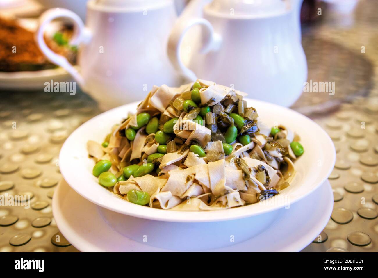 Beliebte chinesische vegetarische Küche mit breiten Bohnen, gebraten mit Tofustreifen und eingelegtem Schneekohl. Stockfoto