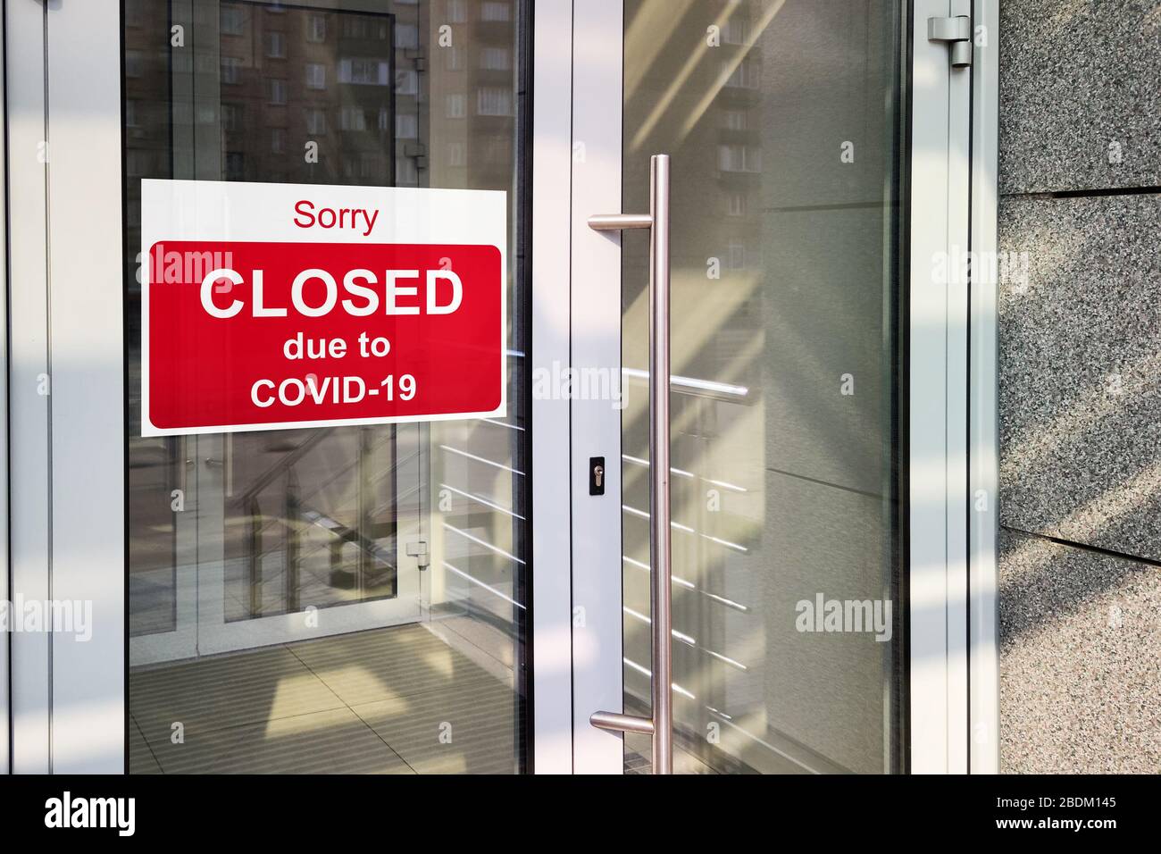 Business Center wegen COVID-19 geschlossen, Schild mit Entschuldigung im Türfenster. Geschäfte, Restaurants, Büros und andere öffentliche Orte sind während des Co vorübergehend geschlossen Stockfoto