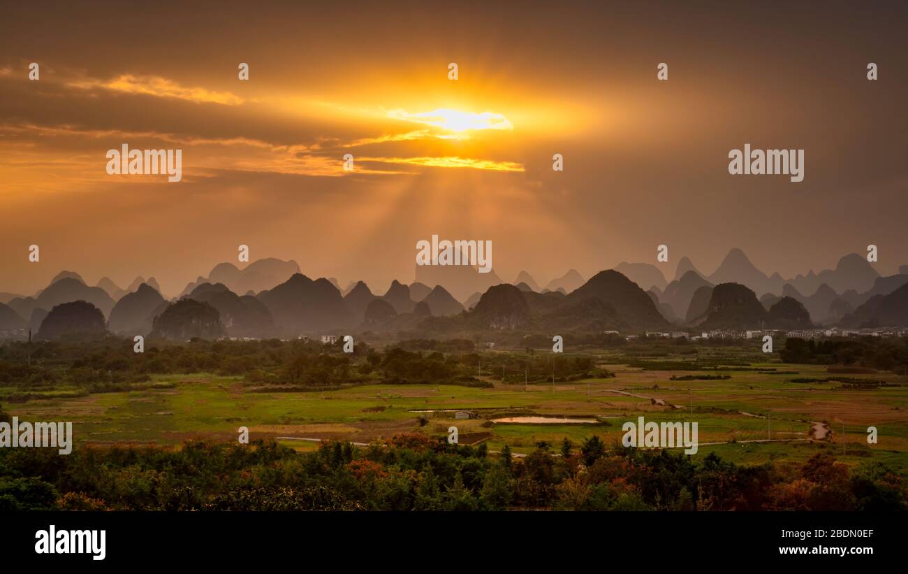 Sonnenstrahlen, die durch Wolken auf den Kalksteinbergen von Guilin, China, scheinen. Stockfoto