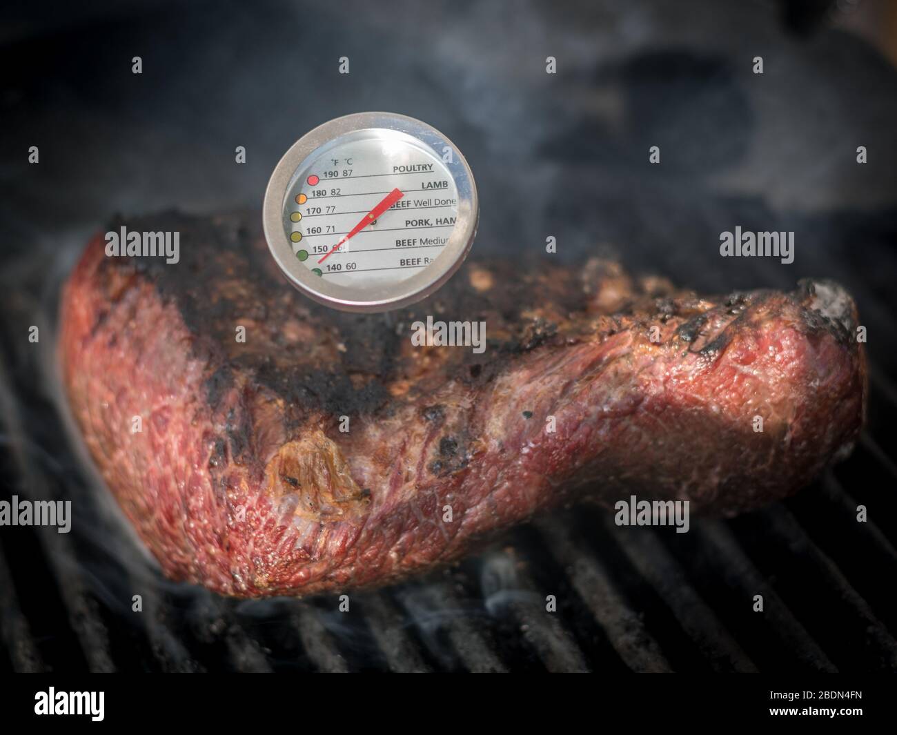 Isolierte Nahaufnahme eines köstlichen Rindfleisch Picanha Fleisch Laib Braten auf einem heißen Grill mit einem Temperaturmesser - Israel Stockfoto