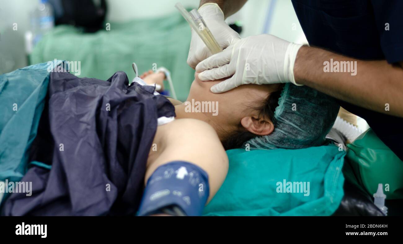 Der Arzt des Anästhesisten wendet den Endotrachealtubus auf den Patienten an. Geringe Schärfentiefe Stockfoto