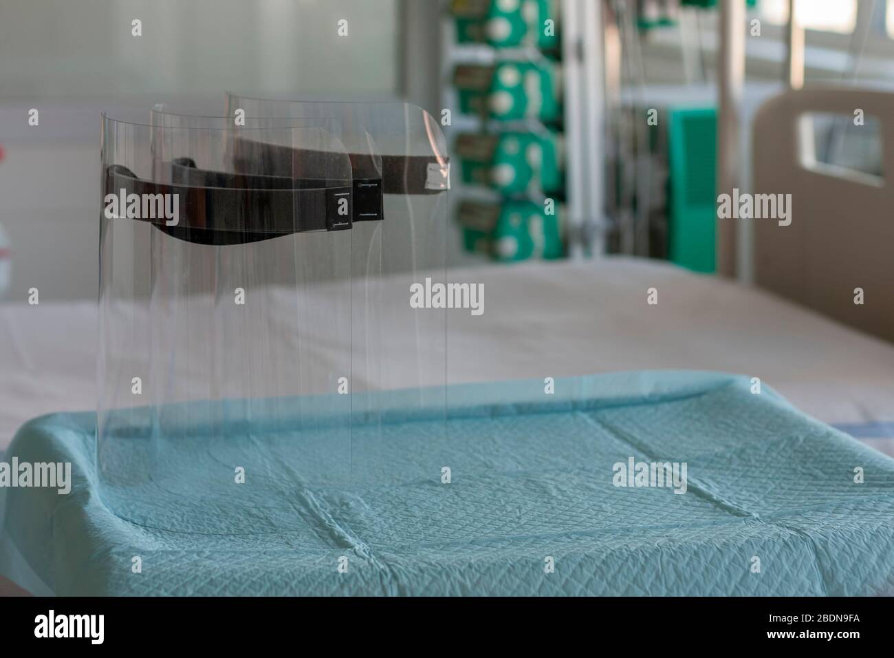 Drei Kunststoff-Schutzschilde auf dem Tisch auf der Intensivstation im Krankenhaus, persönliche Schutzausrüstung zum Schutz vor dem Virus covid-19. Stockfoto