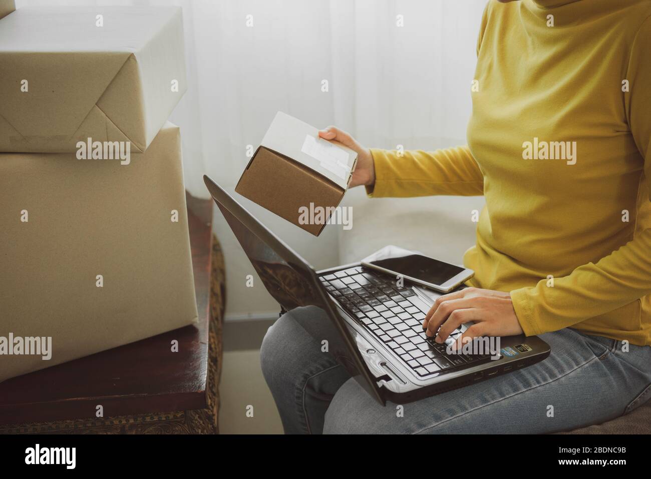 Frau hält eine Box zu bereiten, um den Kunden nach der Bestellung zu Hause liefern.Arbeit von zu Hause und Marketing-Online-oder Startup-Kleinunternehmen c Stockfoto