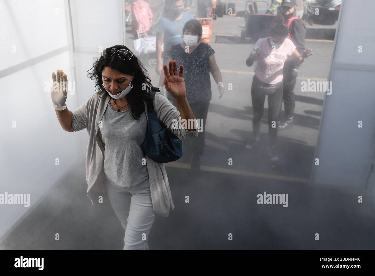 Santiago, Chile. April 2020. Die Verbraucher passieren einen Desinfektionstunnel, bevor sie in Santiago, Chile, am 8. April 2020 auf einen Markt kommen. Kredit: Jorge Villegas/Xinhua/Alamy Live News Stockfoto