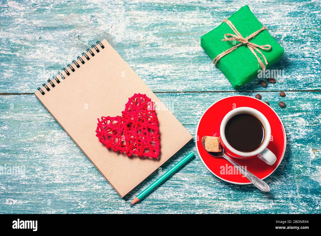 Notizblock, Tasse Kaffee, Schachtel mit Geschenk auf einem blauen Holztisch. Platz für Text, Draufsicht Stockfoto