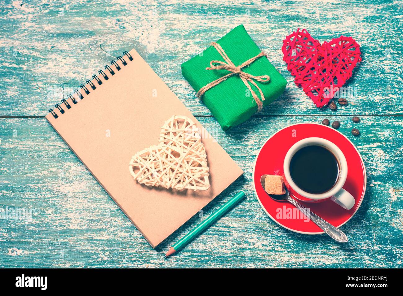 Notizblock, Tasse Kaffee, Schachtel mit Geschenk auf einem blauen Holztisch. Platz für Text, Draufsicht Stockfoto