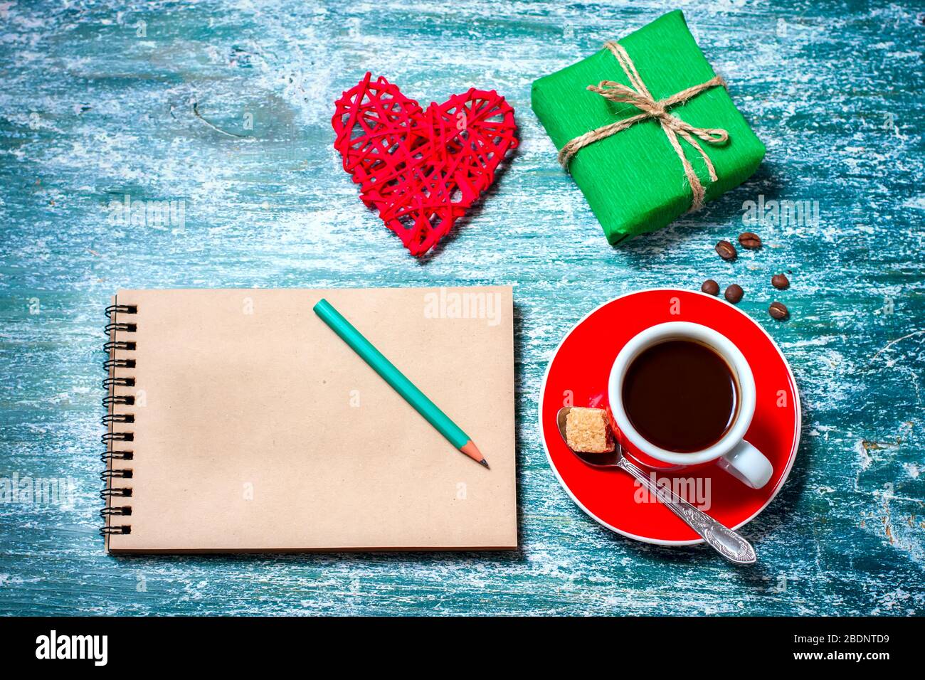 Notizblock, Tasse Kaffee, Schachtel mit Geschenk auf einem blauen Holztisch. Platz für Text, Draufsicht Stockfoto