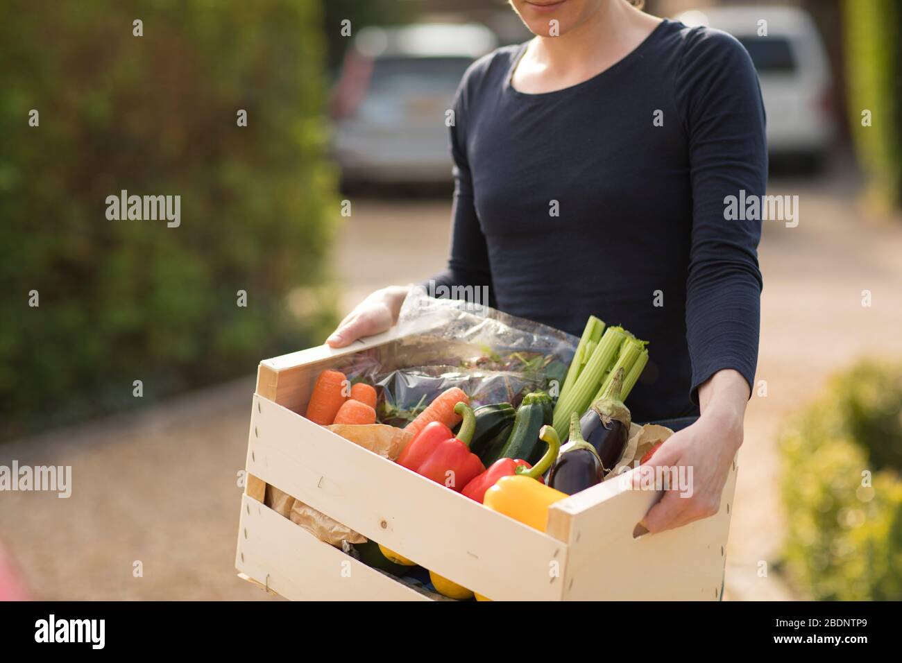 Eine Frau erhält am Mittwoch, April, eine Gemüsekiste in einem Wohnhaus in Guildford Surrey, Großbritannien. 8, 2020. Fotograf: Jason Alden Stockfoto