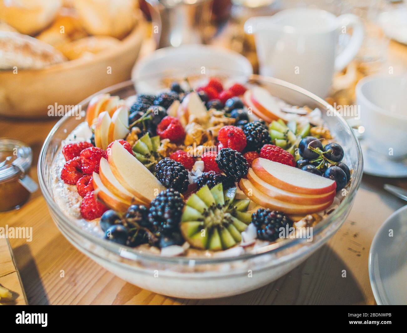 Köstliche hausgemachte Müslischale / bircher Müsli mit frischem Obst auf dem Frühstückstisch Stockfoto