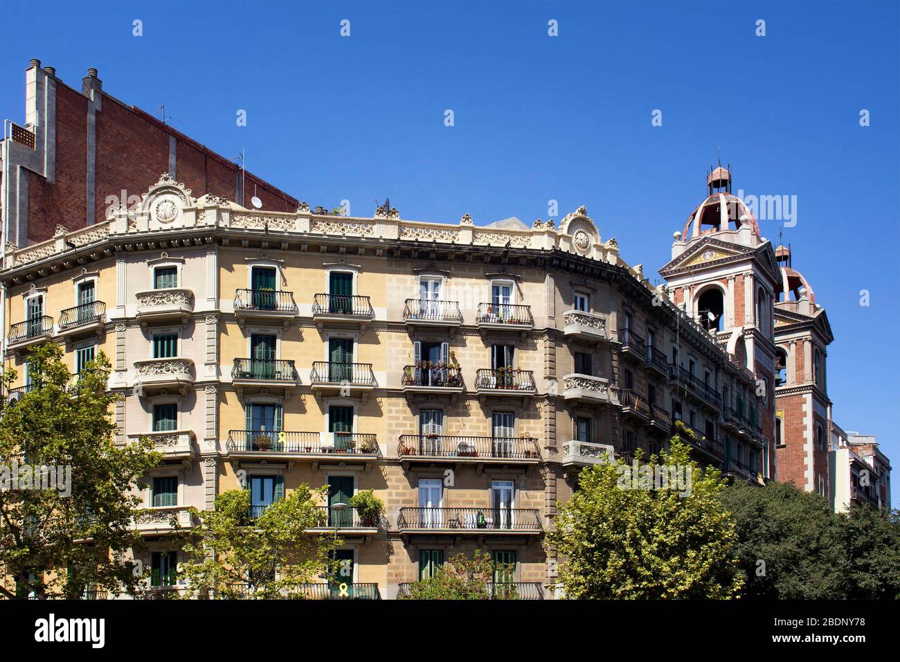 Blick auf traditionelle, historische, typische Wohnbauten in Barcelona mit spanischem/katalanischem Baustil. Es ist ein sonniger Sommertag. Stockfoto