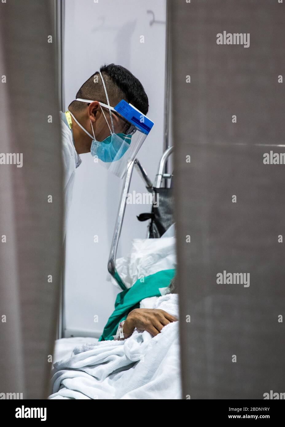NEW YORK, USA - 07. April 2020 - SPC. Aian Foronda, dem Krankenhaus 531st Hospital Center zugeordnet, kümmert sich um einen COVID-19-Patienten in Javits New York Medical Stat Stockfoto