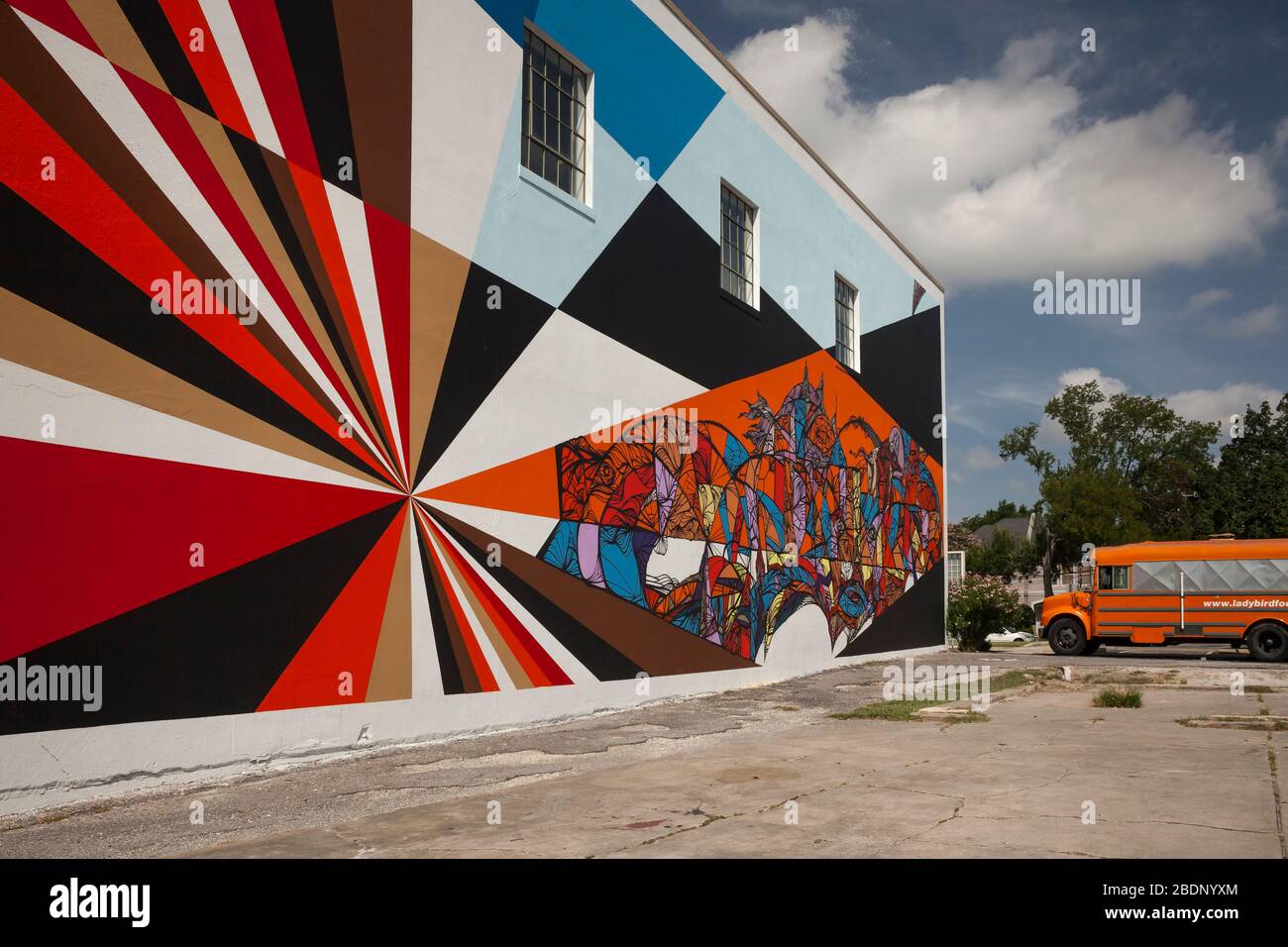 Horizontale Ansicht eines farbenfrohen Wandbildes bei einem orangefarbenen Retro-Bus in der Main St, Museumsviertel, Midtown Houston, Texas Stockfoto
