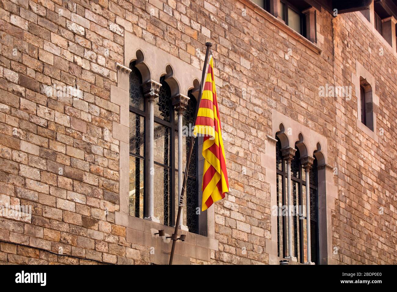 Blick auf die katalanische Flagge im historischen, alten Gebäude im Stadtteil Ciutat Vella (Gotisches Viertel) in Barcelona. Es ist ein sonniger Sommertag. Stockfoto