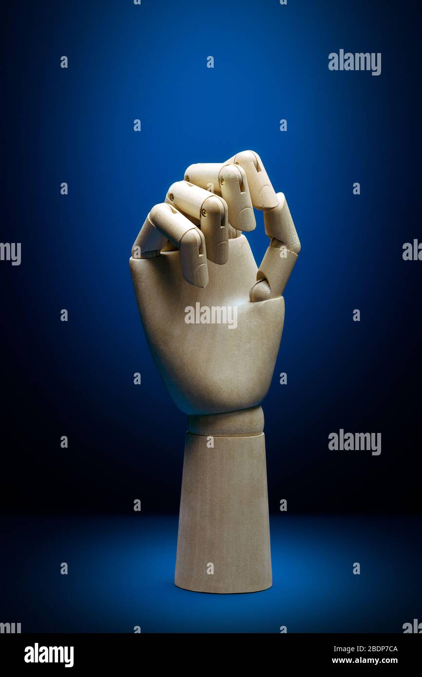 Künstliche Intelligenz Holzhandansicht mit geschlossenen Fingern auf einem klassischen blauen Hintergrund Stockfoto