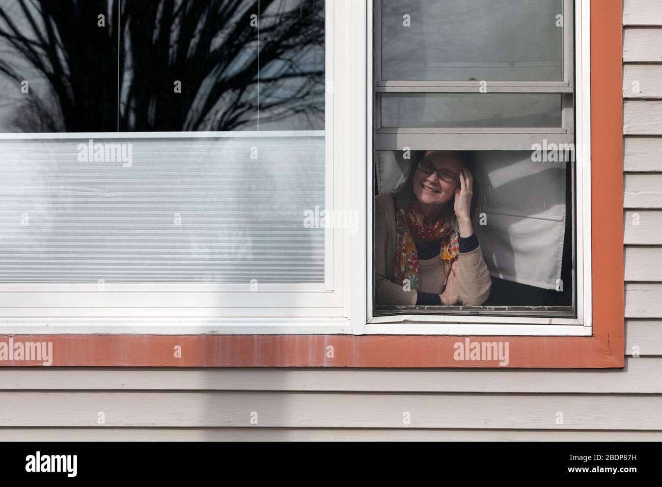 Eine Frau schaut ihr Fenster während der STAT-Hausbestellung in Boston Massachusetts USA aus Stockfoto