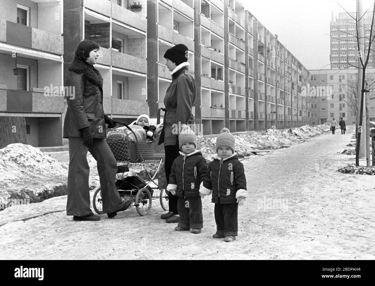 15. Januar 1980, Sachsen, Leipzig: Eine Mutter mit Zwillingen und eine mit  Kinderwagen spricht in Winter-