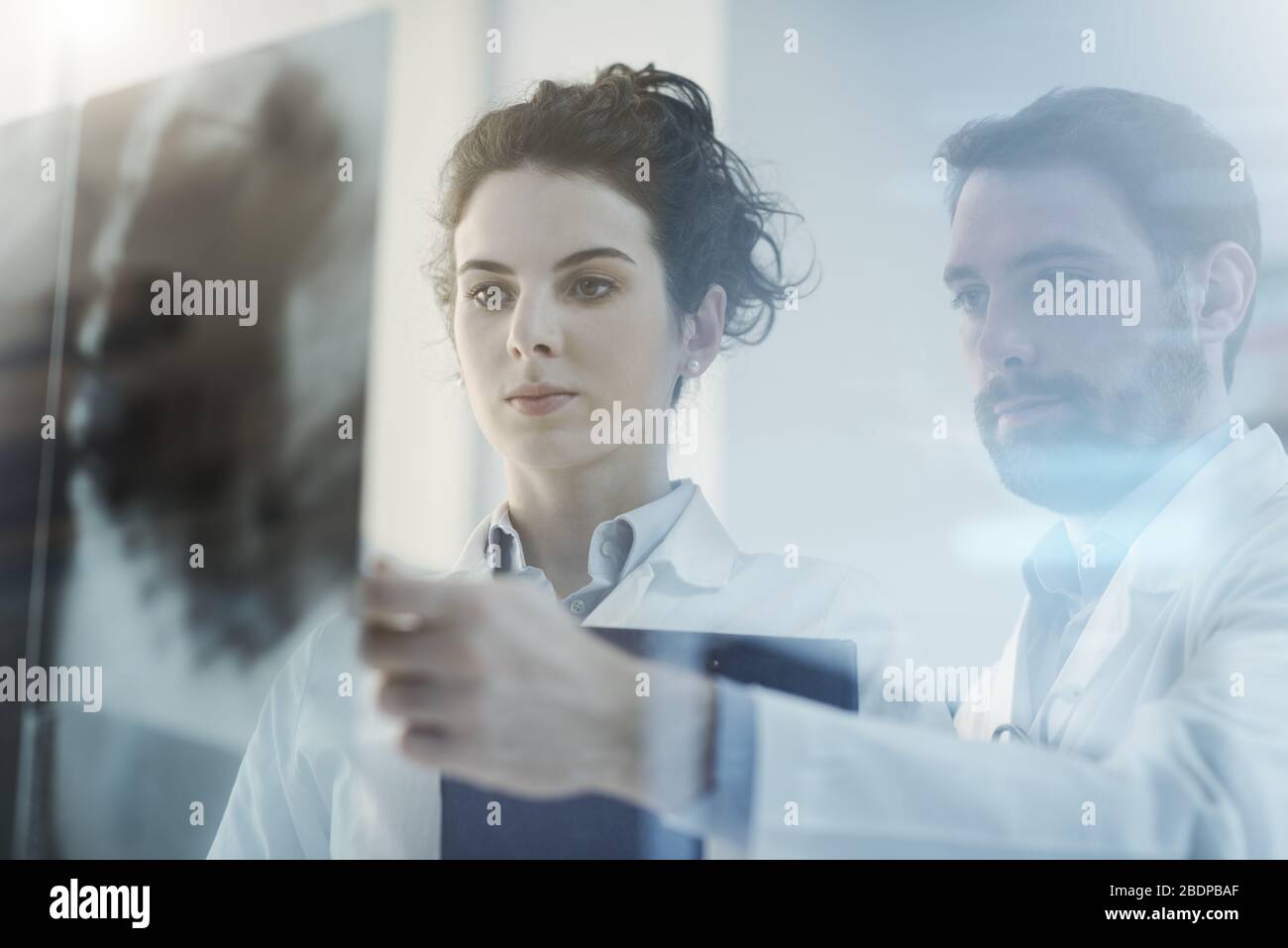 Professionelle Ärzte untersuchen Röntgenaufnahmen und diskutieren, medizinische Untersuchungen und das Konzept des Gesundheitswesens Stockfoto