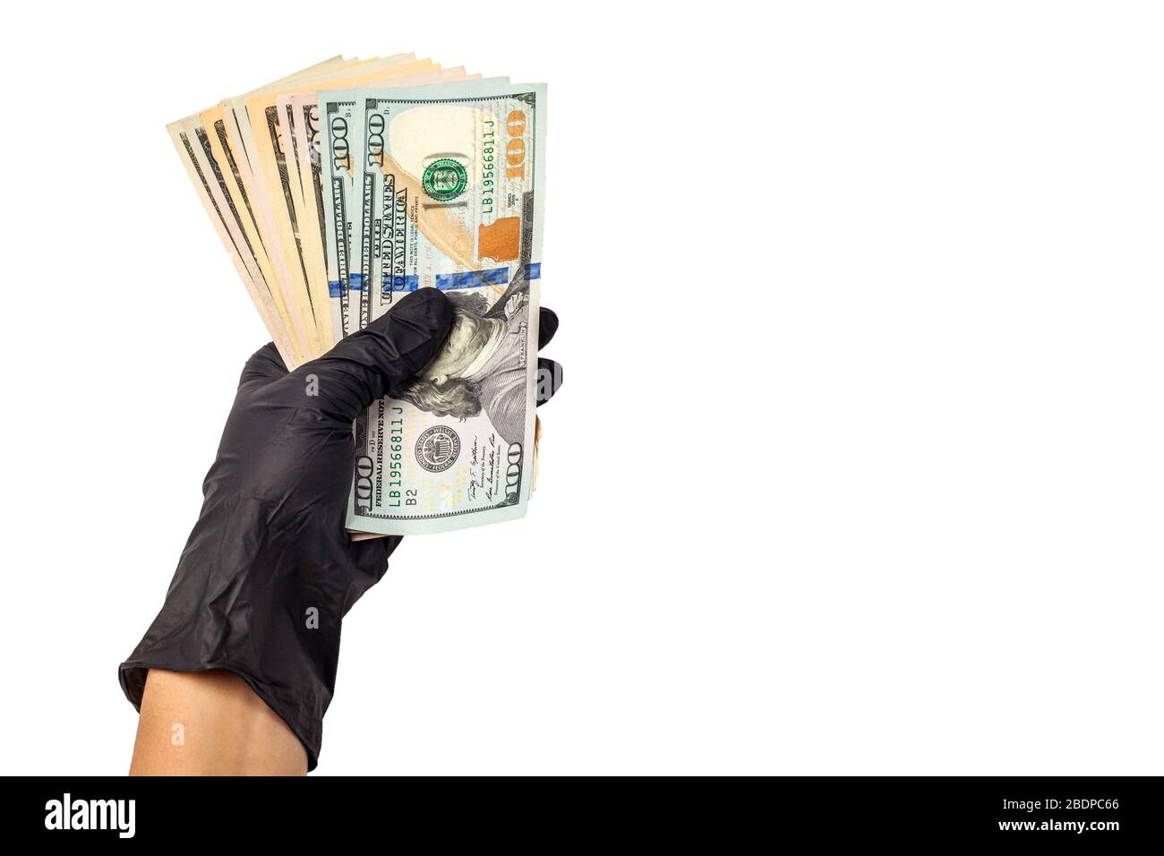 Hand in medizinischen Handschuhen halten eine Packung Dollar. Das Konzept der Infektion für Geld, schmutziges Geld, bezahlte Drogen, Behandlungsgebühren, Bestechungsgelder, illegale Operationen. Isoliert auf weißem Hintergrund Stockfoto