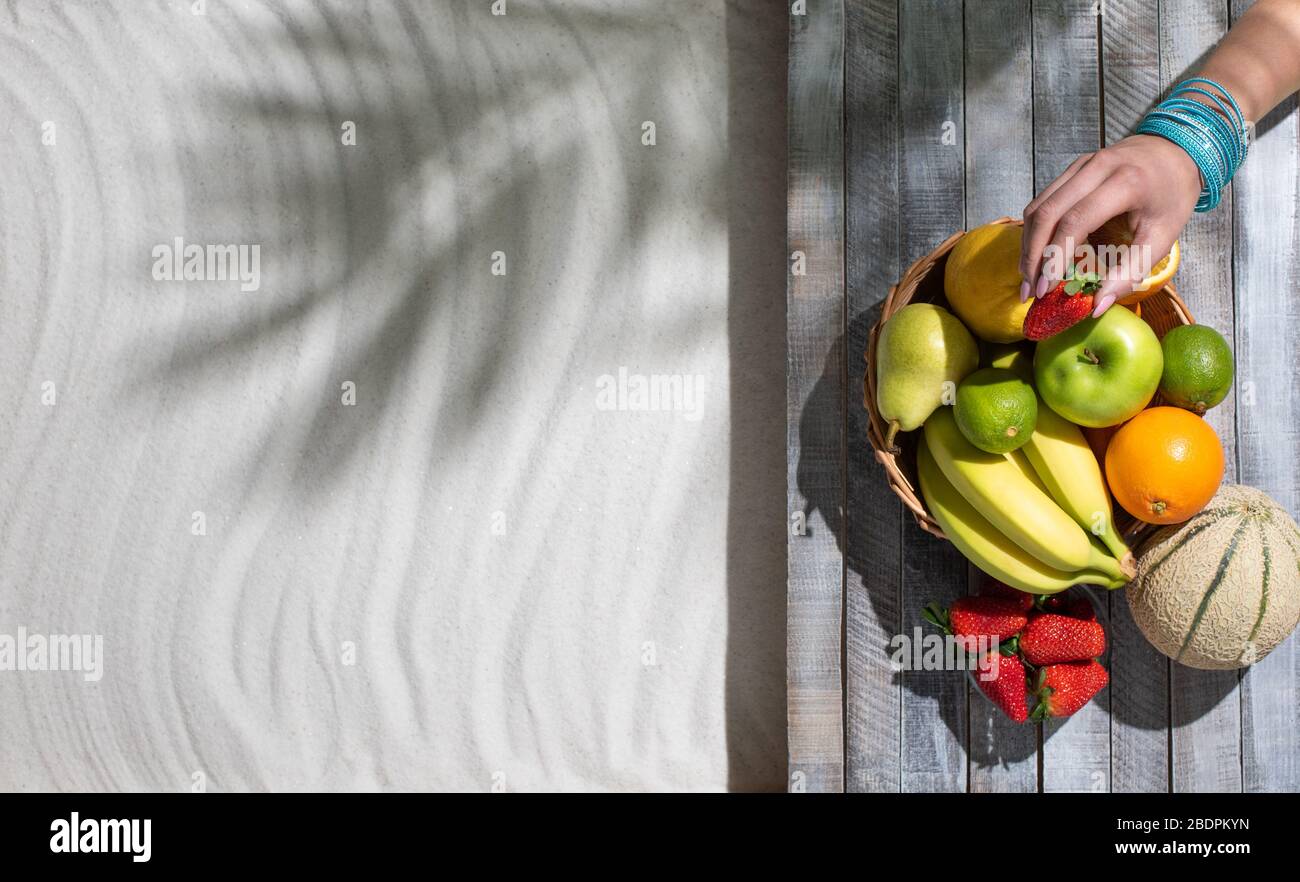 Am Strand liegende Frau, die Obst, Sommerferien und gesundes Esskonzept isst, leerer Kopierraum Stockfoto