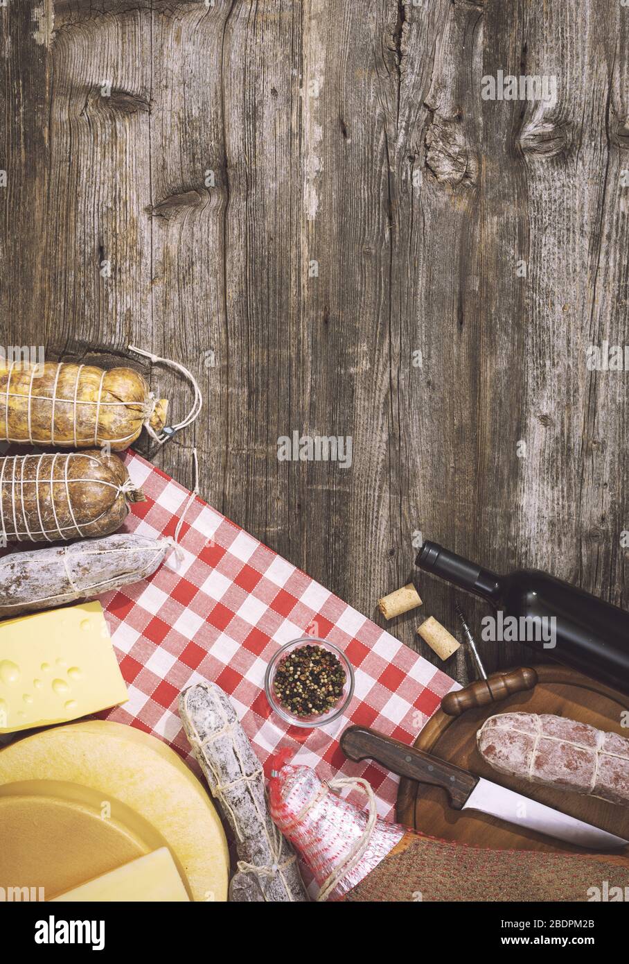 Traditionelle italienische Gourmetküche und Rotweinflasche, eine Auswahl an Käse und Salami auf einem rustikalen Holztisch Stockfoto