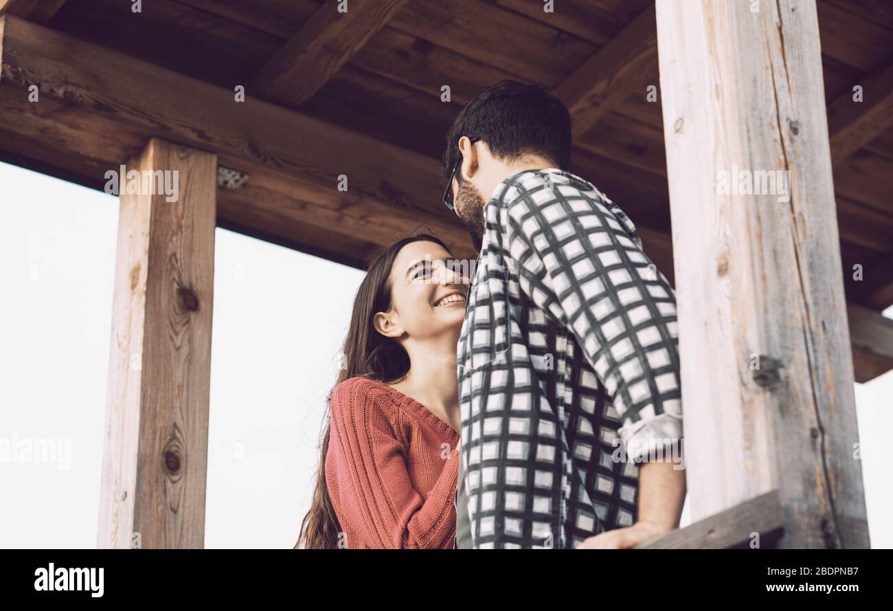 Ein romantisches Liebespaar starrt sich in einer Holzgazebo, Gefühle und Beziehungskonzept an Stockfoto