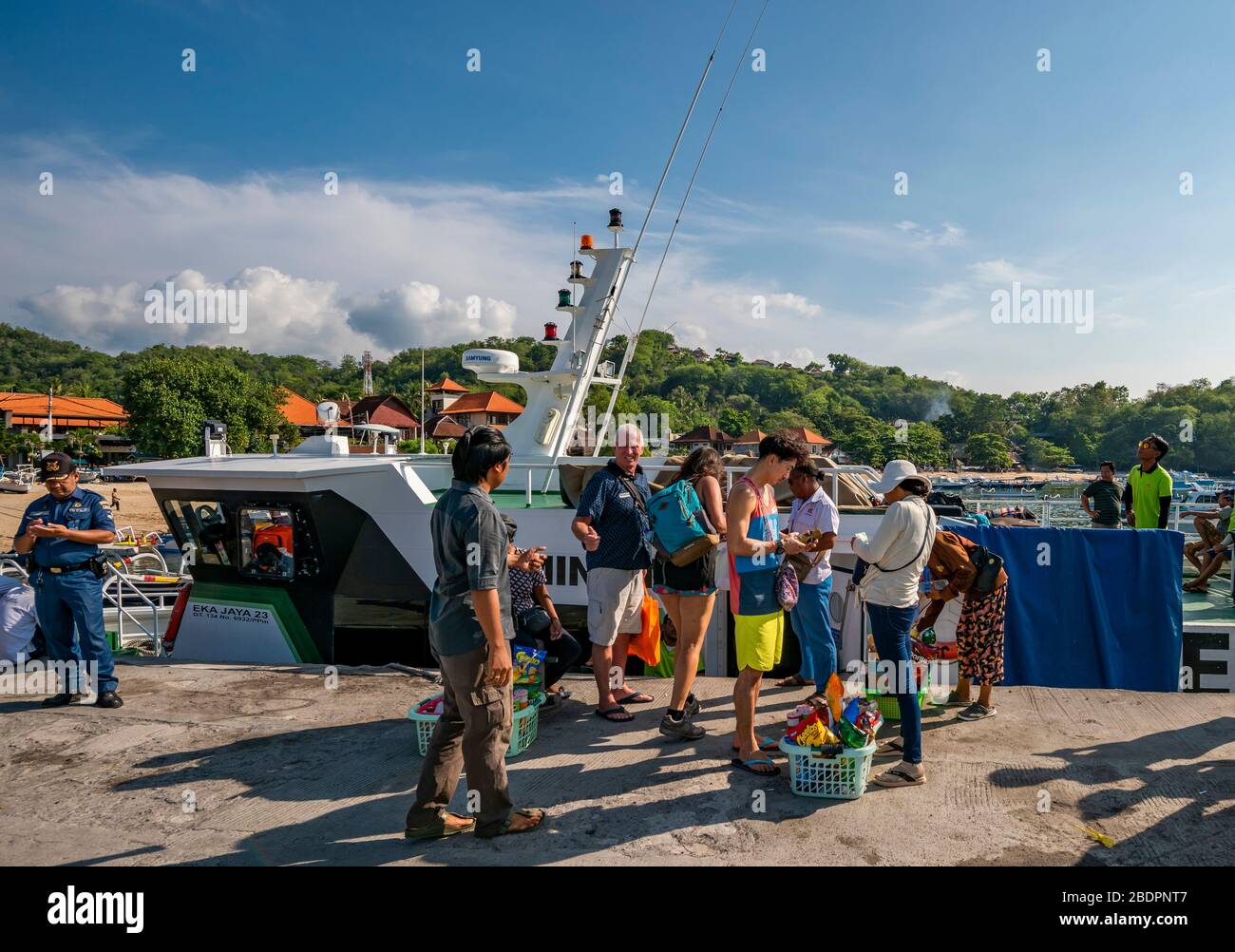 Horizontaler Blick auf Passagiere, die mit einer Fähre am Hafen von Padang Bai in Bali, Indonesien, einsteigen. Stockfoto