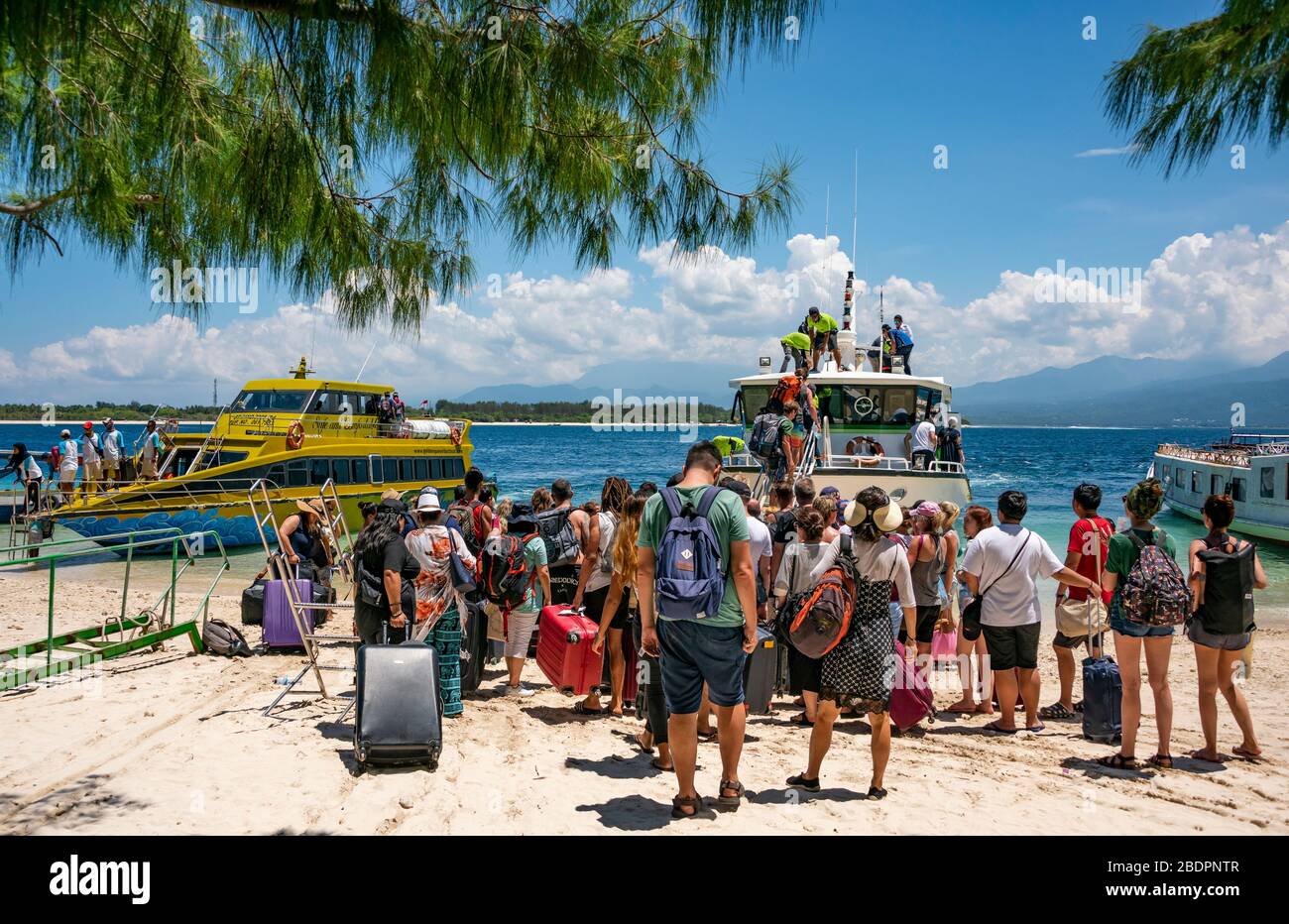 Horizontaler Blick auf Touristen, die Fähren in Gili Trawangan, Indonesien, einsteigen. Stockfoto