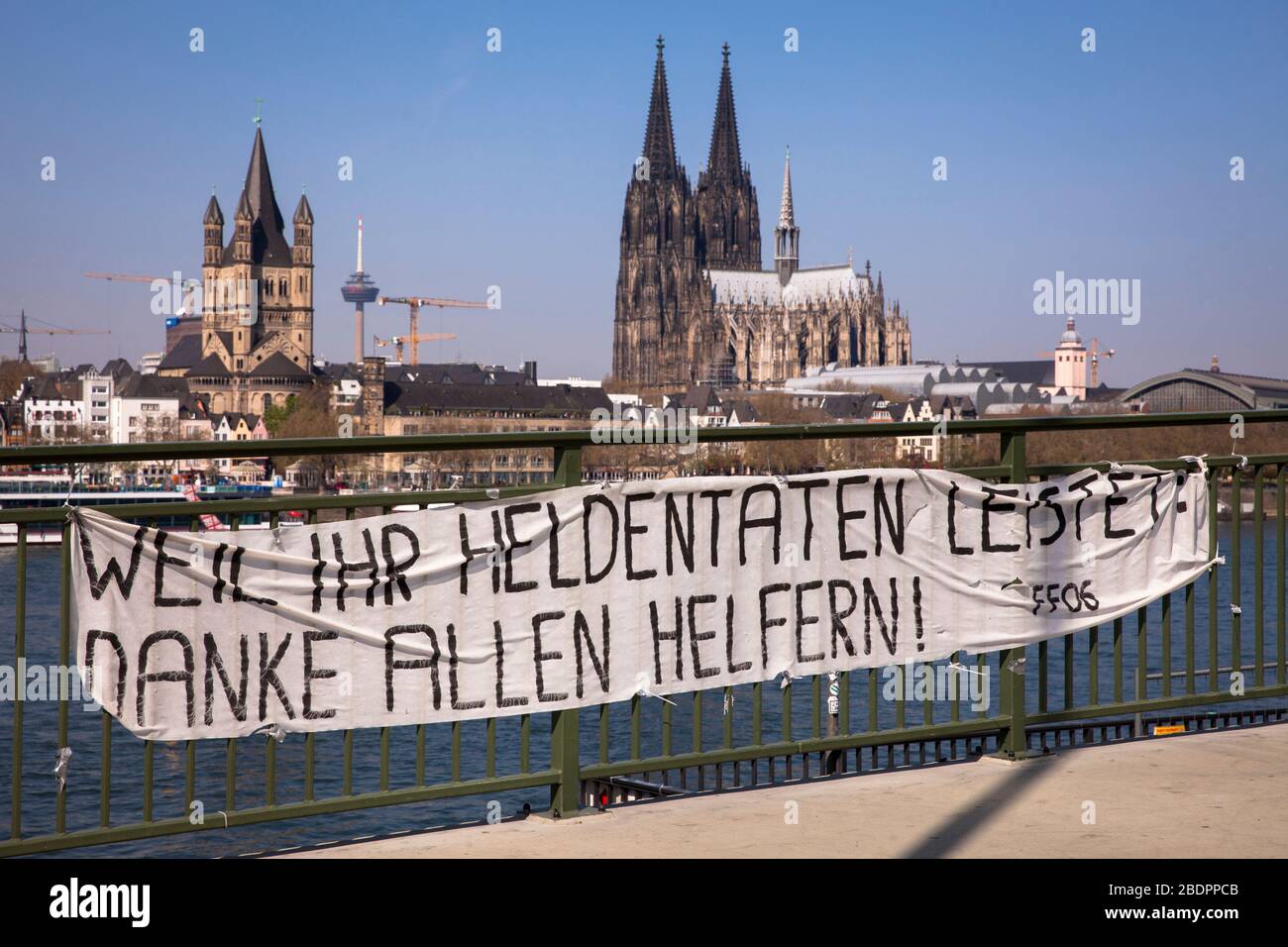 Coronavirus/Covid 19-Ausbruch, 8. April. 2020. Ein Banner an der Deutzer Brücke dankt den Helfern beim Blick auf den Dom, Köln, Deutschland. Coronav Stockfoto