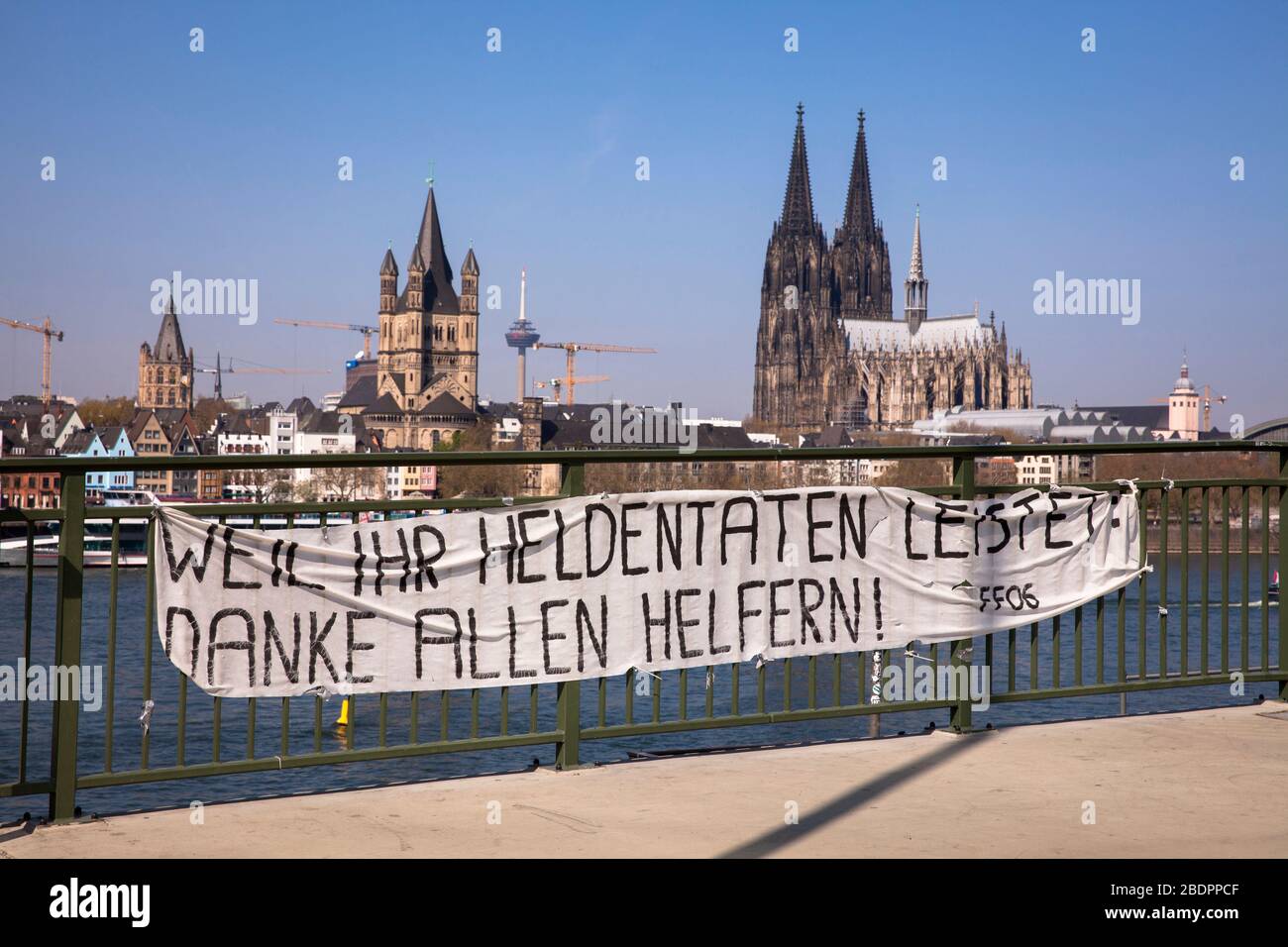 Coronavirus/Covid 19-Ausbruch, 8. April. 2020. Ein Banner an der Deutzer Brücke dankt den Helfern beim Blick auf den Dom, Köln, Deutschland. Coronav Stockfoto