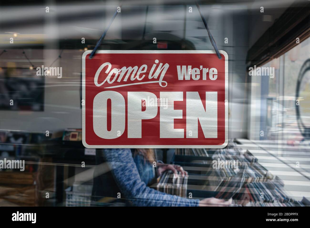 Ein Geschäftszeichen, das in einem Fenster eines Musik-/Plattengeschäfts „Come in We're Open“ steht. Stockfoto