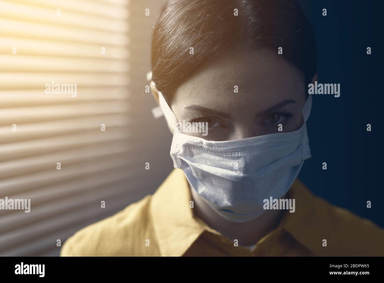 Frau, die eine chirurgische Maske trägt und Kamera, Kovid-19-Ausbruch und Virus-Ansteckungskonzept betrachtet Stockfoto