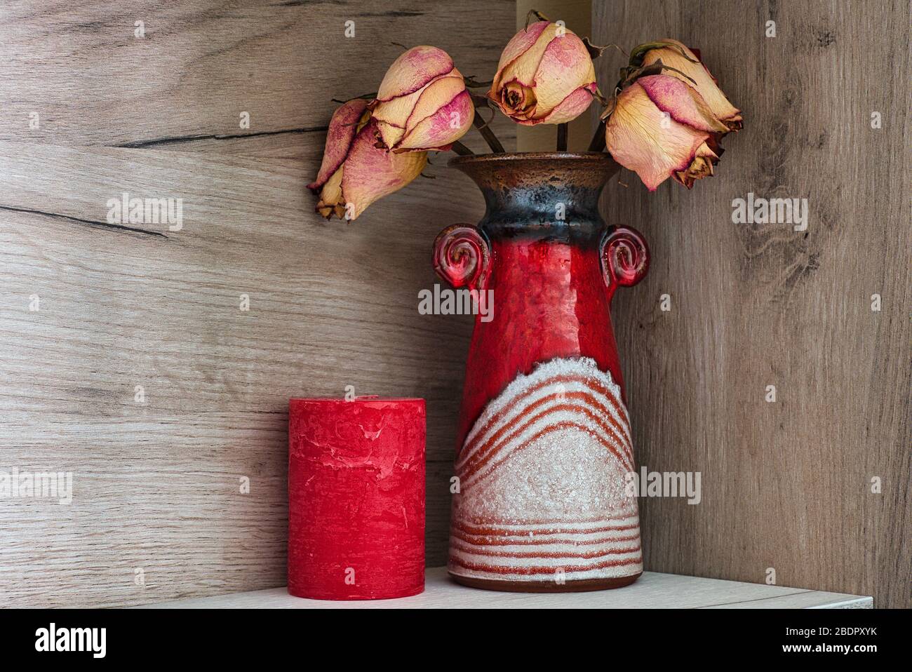 Rote Vase und Kerze Natur morte Bild in Pastellfarben, trockene Rosen Stockfoto