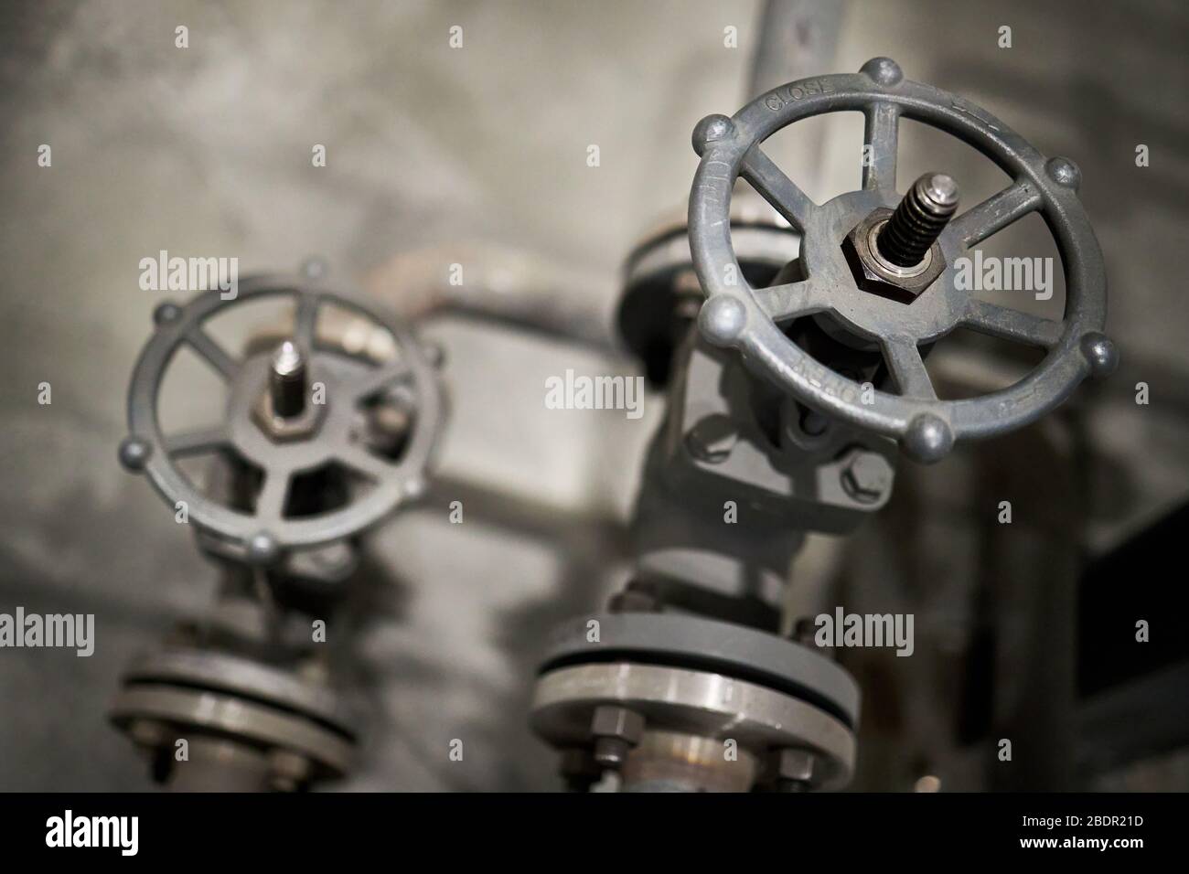 Nahaufnahme des industriellen Ventilpaares mit Fokus auf Vordergrundlüftung mit offener Beschriftung und Schließen an Steuerruder und Blinker, Pfeil mit Kopie Stockfoto