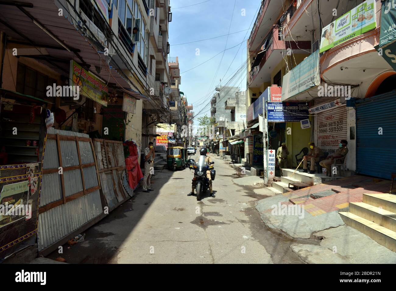 Noida. April 2020. Ein Polizist patrouilliert im Dorf Chaura, nachdem es am 9. April 2020 in Noida, Indien, versiegelt wurde. Behörden im nordindischen Bundesstaat Uttar Pradesh sagten am Mittwoch, dass COVID-19-Hotspots in 15 Distrikten bis zum 15. April vollständig versiegelt werden und das tragen von Gesichtsmasken obligatorisch angeordnet haben. Kredit: Partha Sarkar/Xinhua/Alamy Live News Stockfoto